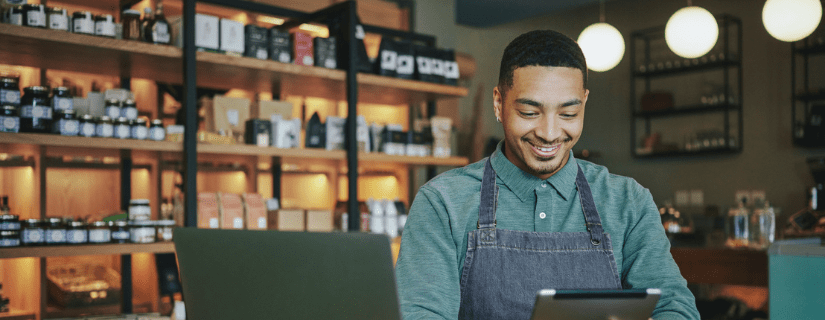 small business owner looking at his ipad in his store.