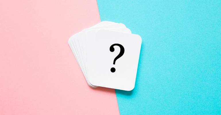 Deck of cards with question mark on top card against pink and blue background