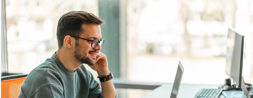 A happy man looking at his CRM database.